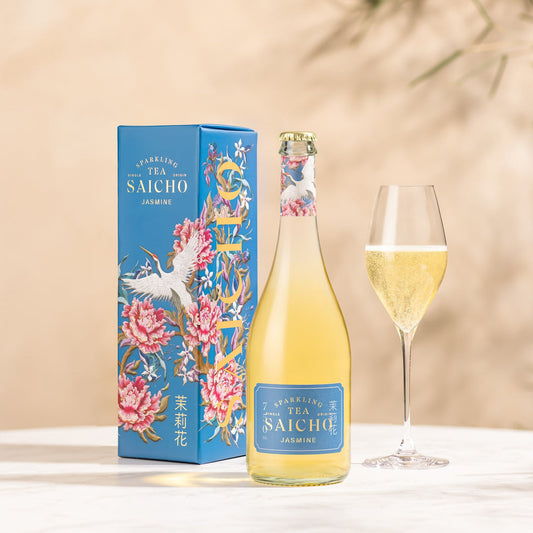 Bottle and box of Saicho Sparkling Jasmine Tea with a glass of tea on a beige background