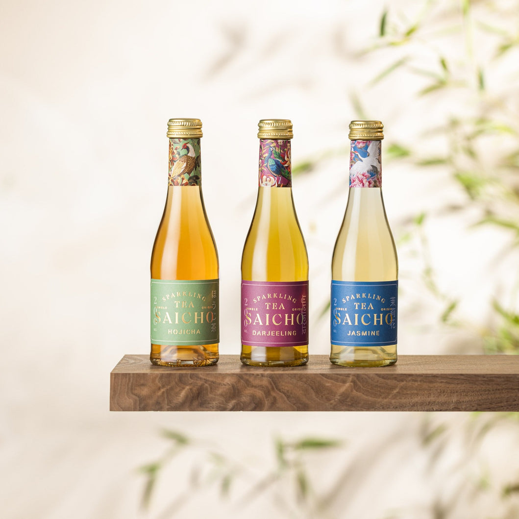 Three bottles of sparkling tea on a wooden shelf with a blurred natural background